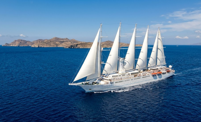 windstar A wide-angle shot of the four-masted Wind Spirit sailing yacht with its massive white sails unfurled against an inky cobalt Aegean Sea